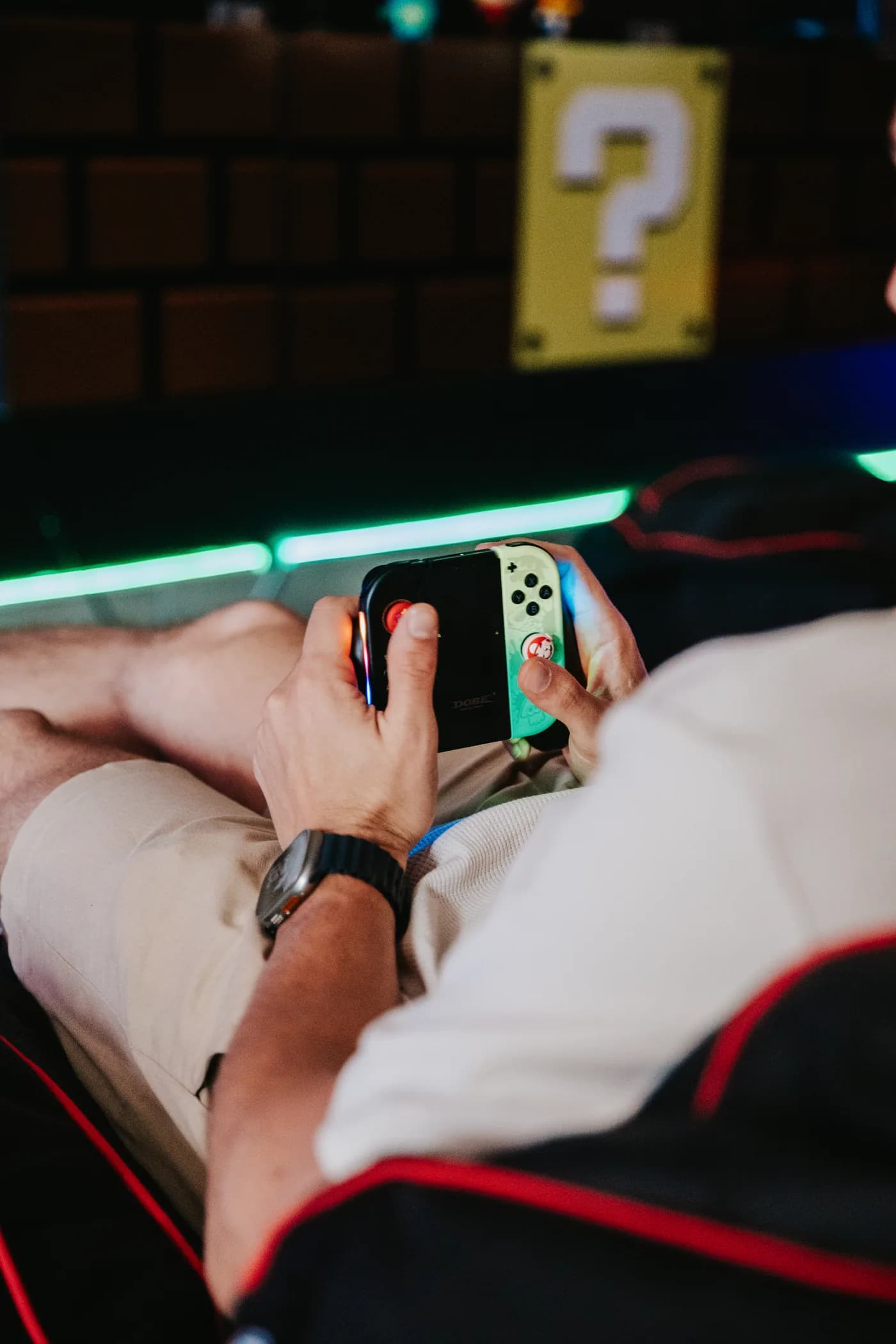 Alguien jugando a la Nintendo Switch frente a la pared de bloques